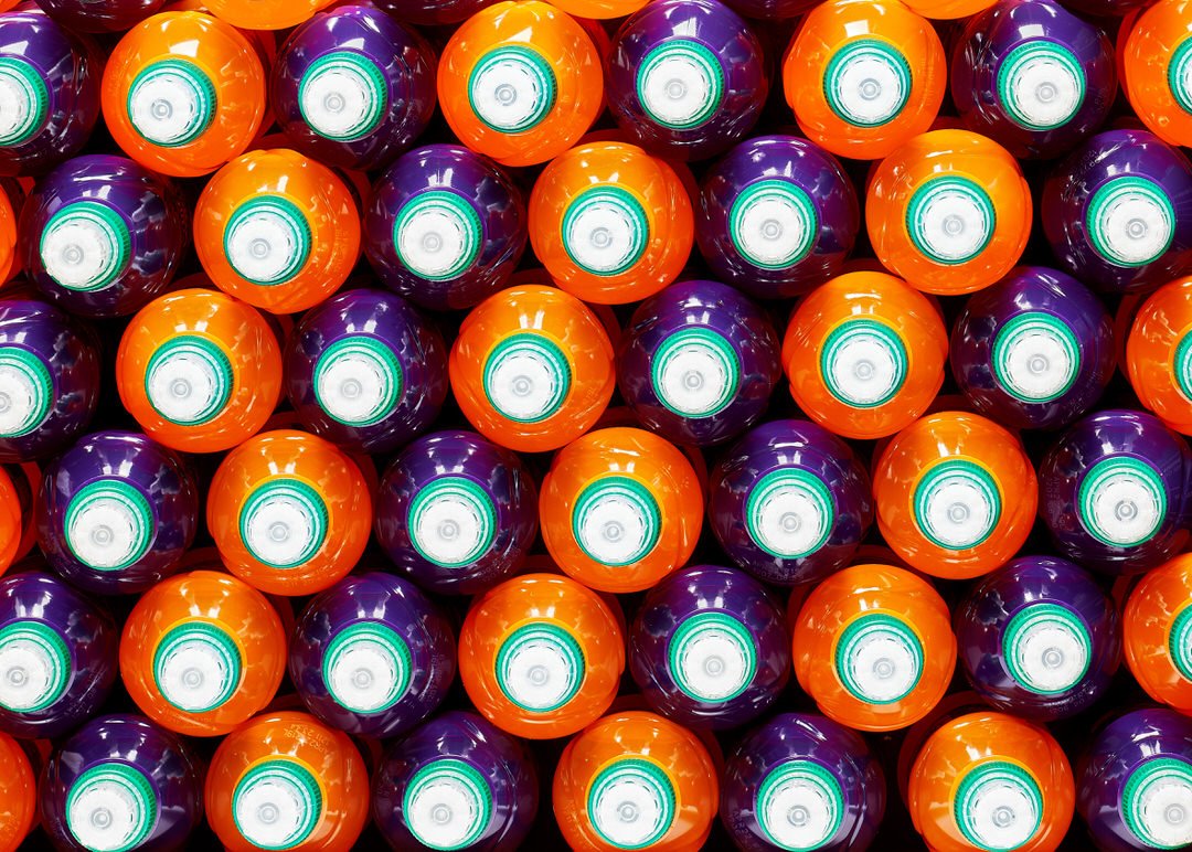 Rows of orange and purple lawn bowls viewed from above, each with a white and green centre ring