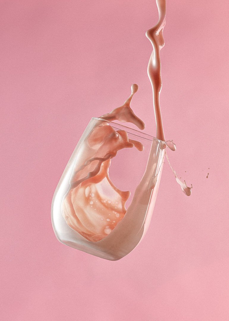 Pink liquid pouring and splashing dynamically inside a tilted glass against a pink background