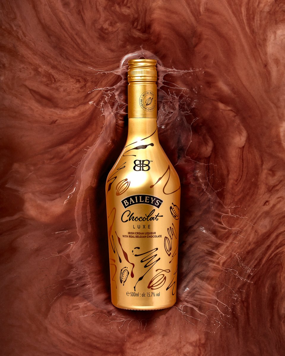 Gold bottle of Baileys Chocolat Luxe Irish cream liqueur with real Belgian chocolate, 500ml, 15.7% vol, set against a swirling chocolate backdrop