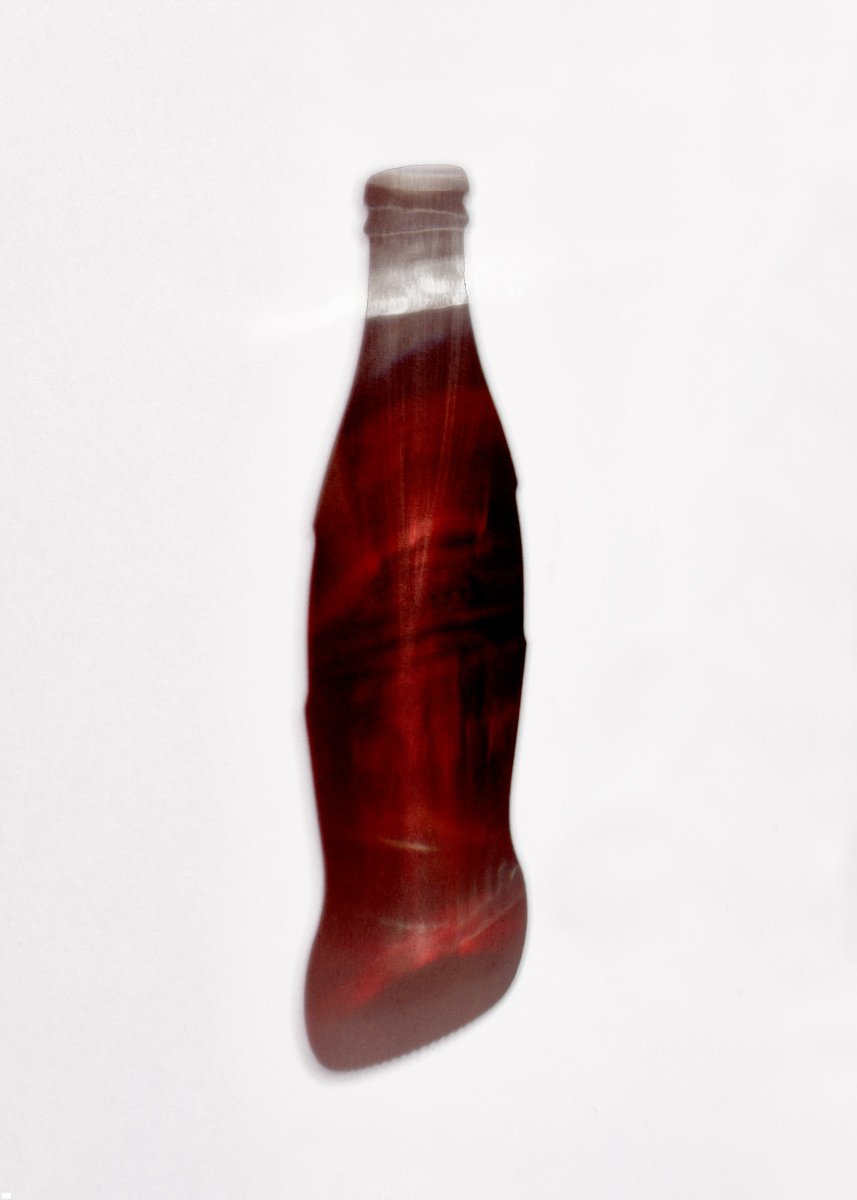 Glass bottle filled with dark cola-coloured liquid, curved and slightly distorted in shape