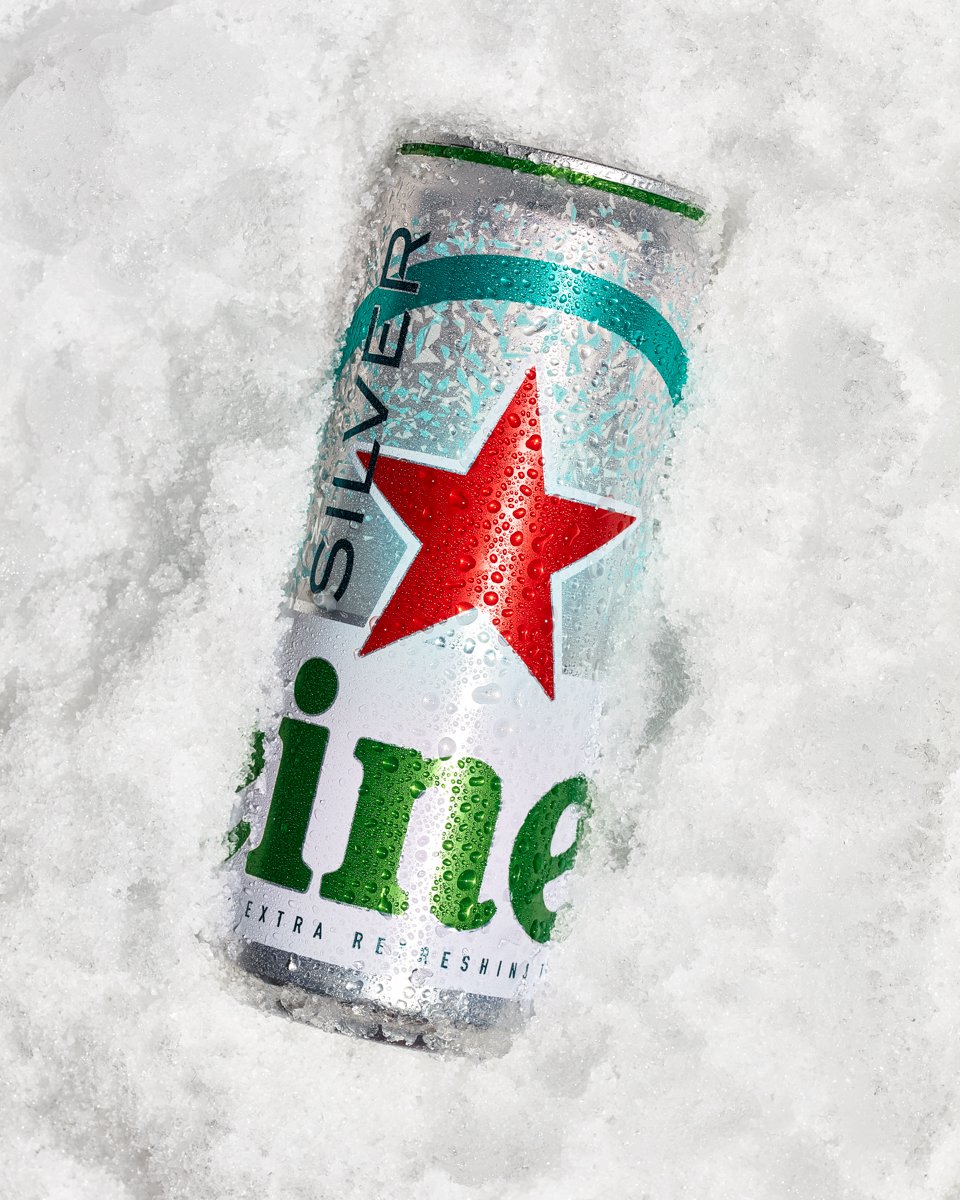 Chilled Heineken Silver beer can with condensation, resting in crushed ice