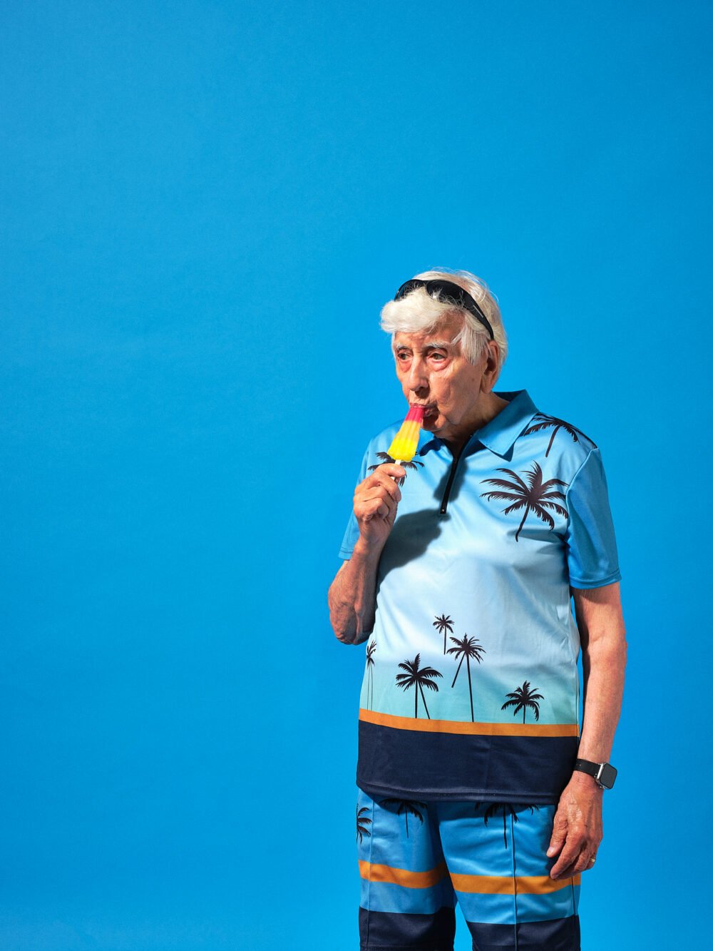 comedic commercial portrait of an old man on holiday eating an ice lolly