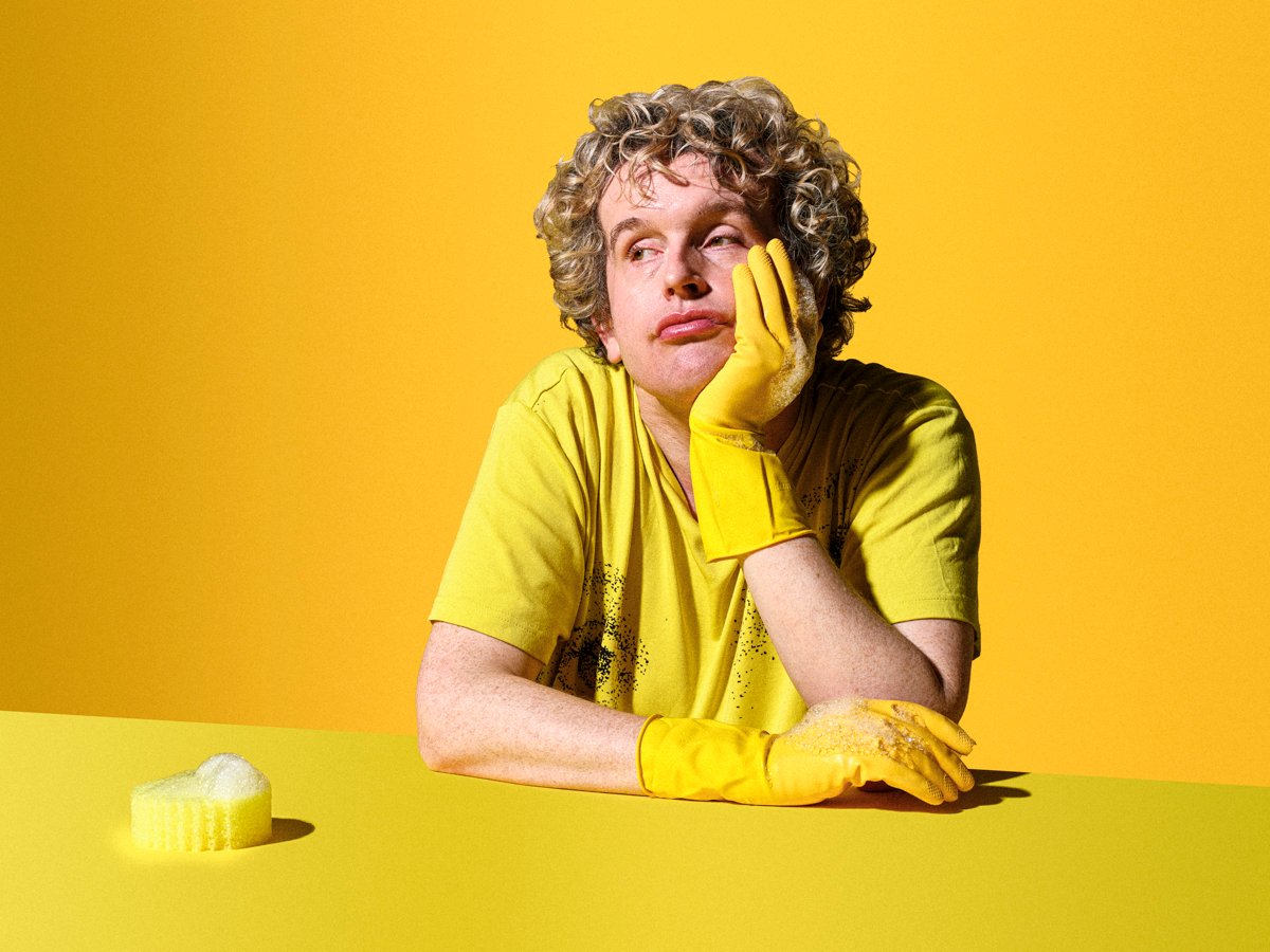 a man in a yellow y shirt with yellow washing up gloves on a yellow photography set looking sad taken by commercial advertising photographer scott choucino represented by agent at large