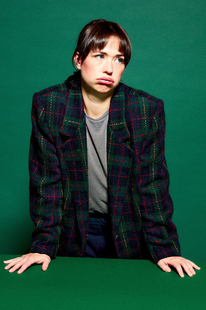 portrait of a teacher in a photographic studio on a green set where she looks very frustrated and defeated