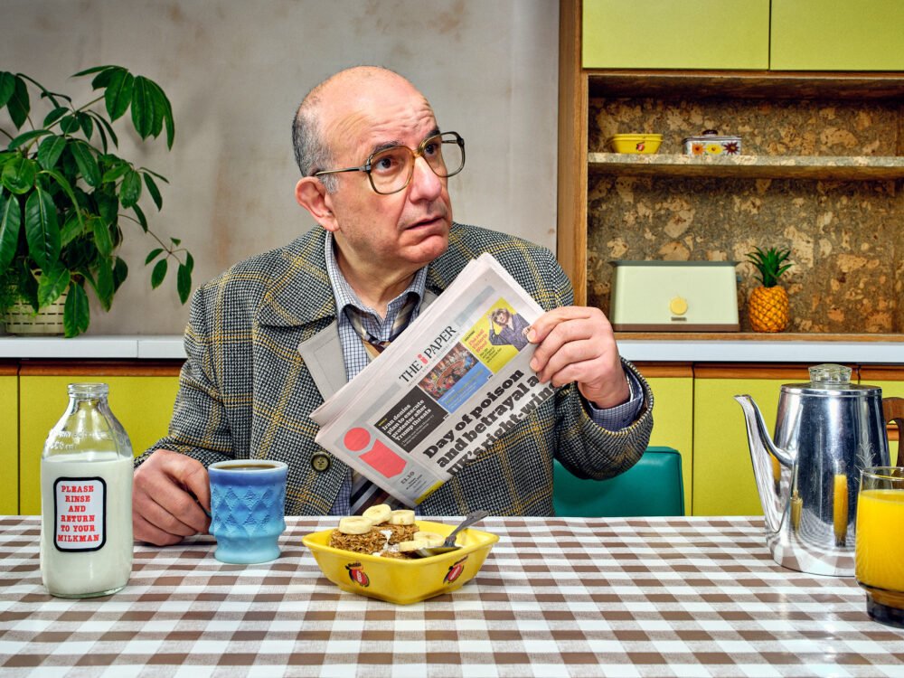 vintage business man looks confused whilst having breakfast in a photographic set