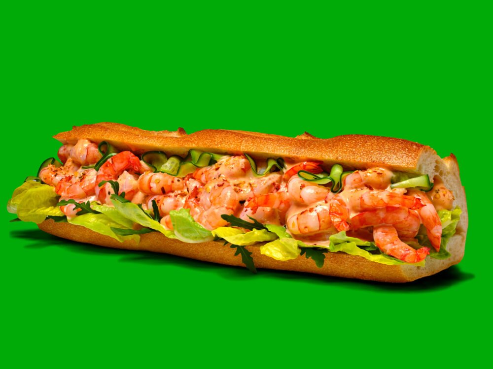 commercial advertising photograph of a prawn baguette on a bright green background