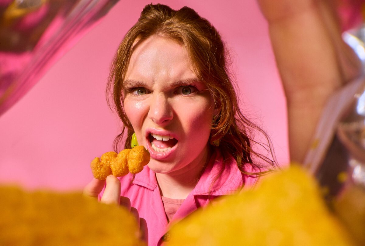 probe lens creative portrait from inside a crisp packet looking out at a lady eating crisps