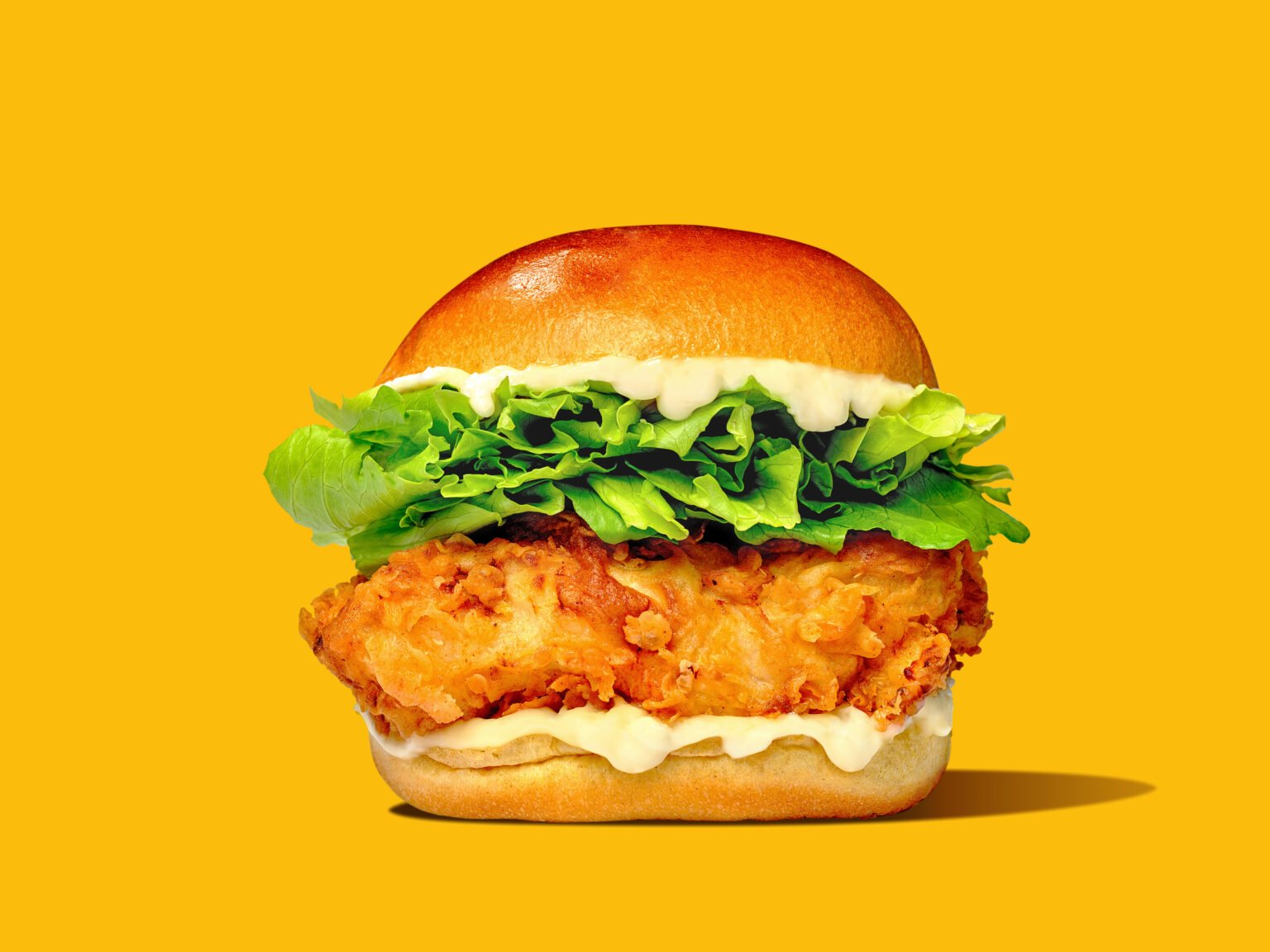 professional food photograph of a mcdonalds style chicken burger on a bright yellow background