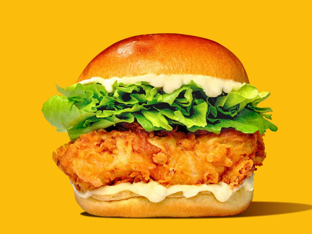 heroic photograph of a chicken burger with dramatic shadows and bright lighting