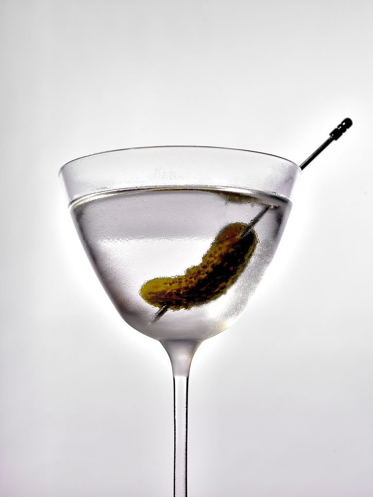 Social First Drinks Content Creator A martini glass with a clear cocktail garnished with a gherkin on a cocktail pick