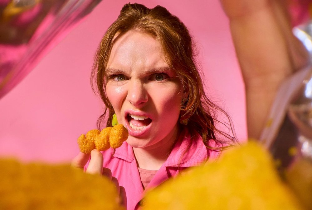 funny comedian making a facial expression whilst eating a crisp taken by London photographer Scott Choucino